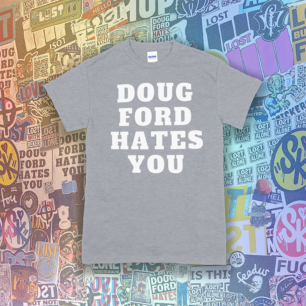 The original Doug Ford Hates You t-shirt. Bold white letters screen printed on a grey shirt. Colorful graffiti stickers make up the background.