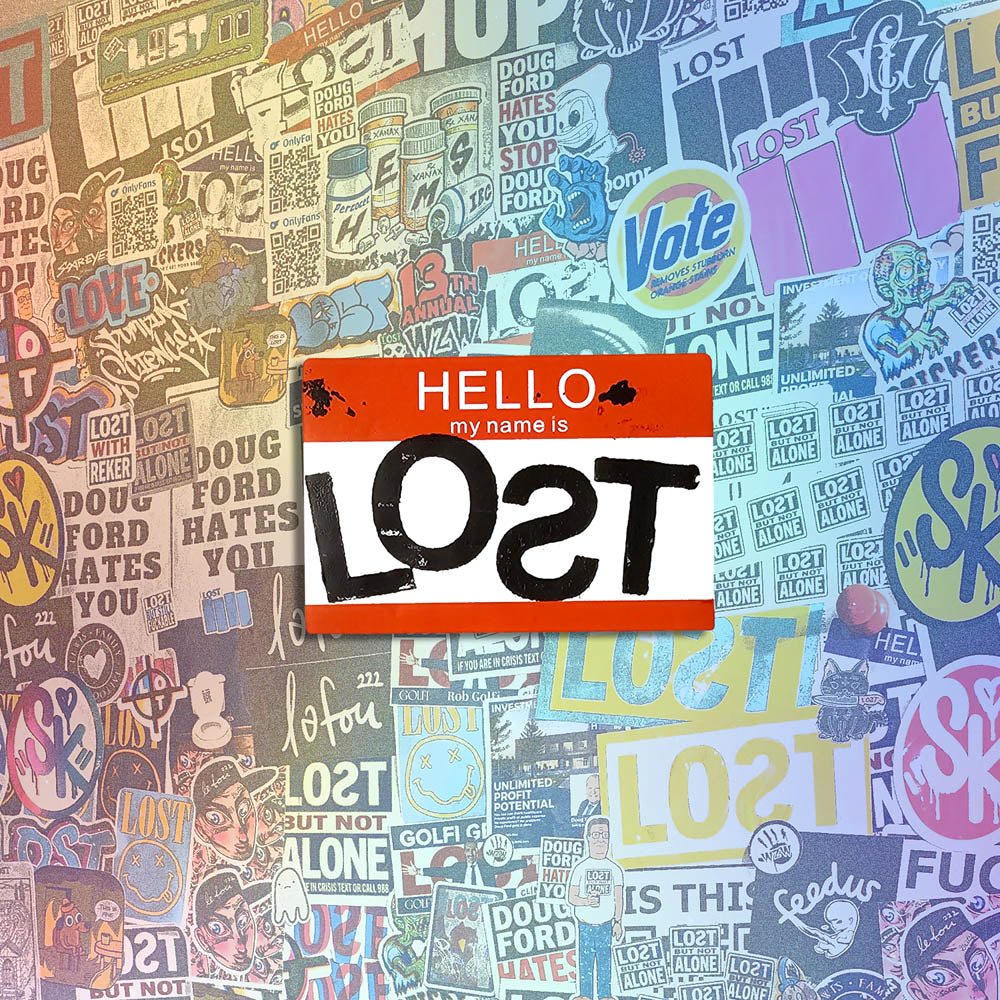 Hello my name is LOST sticker. A red and white nametag sticker stamped with the name LOST with a backwards S. The sticker is set against a wall of stickers from international graffiti artists.