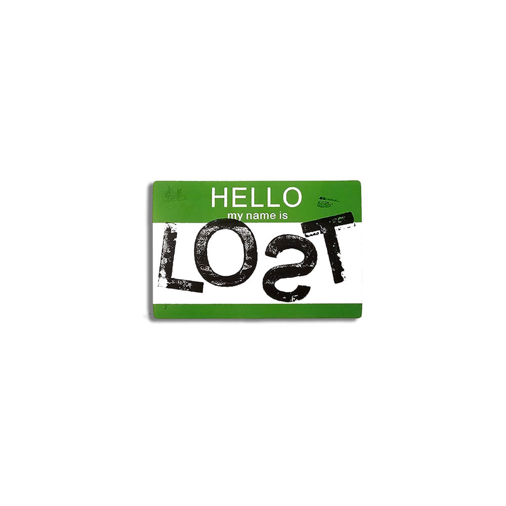 Hello my name is LOST sticker. A green and white nametag sticker stamped with the name LOST with a backwards S. The sticker is set against a plain white Background.