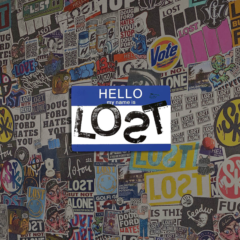 Hello my name is LOST sticker. A blue and white nametag sticker stamped with the name LOST with a backwards S. The sticker is set against a colorful wall of graffiti stickers.